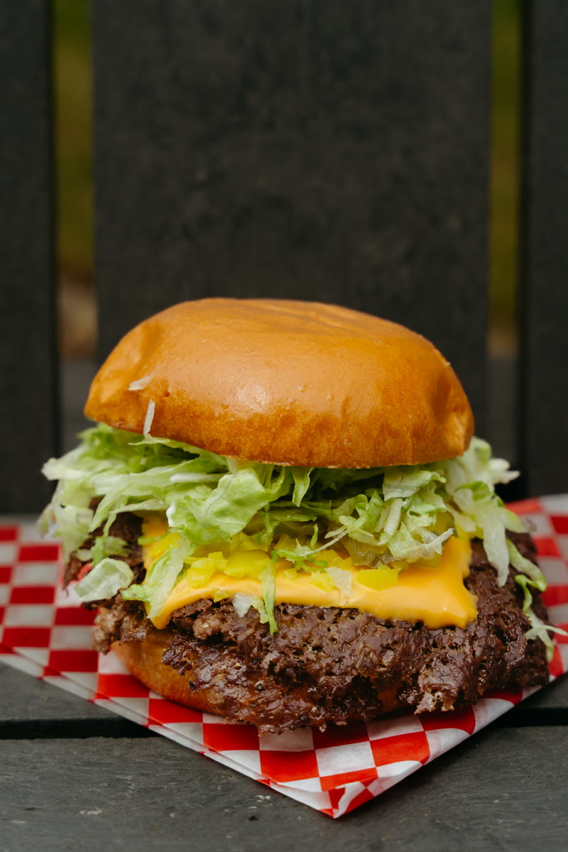 California Love — two smash patties with pickled Californian hot chilli peppers, gooey cheese, fresh lettuce, pickles and mayo on a toasted brioche bun