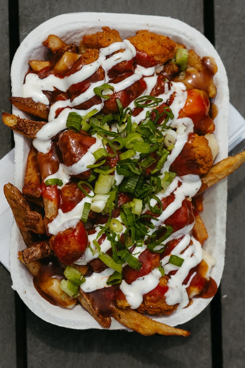 Buffalo Chicken Poutine — hand-cut fries, cheese curds and gravy loaded with crispy fried chicken, buffalo sauce, ranch drizzle and green onion