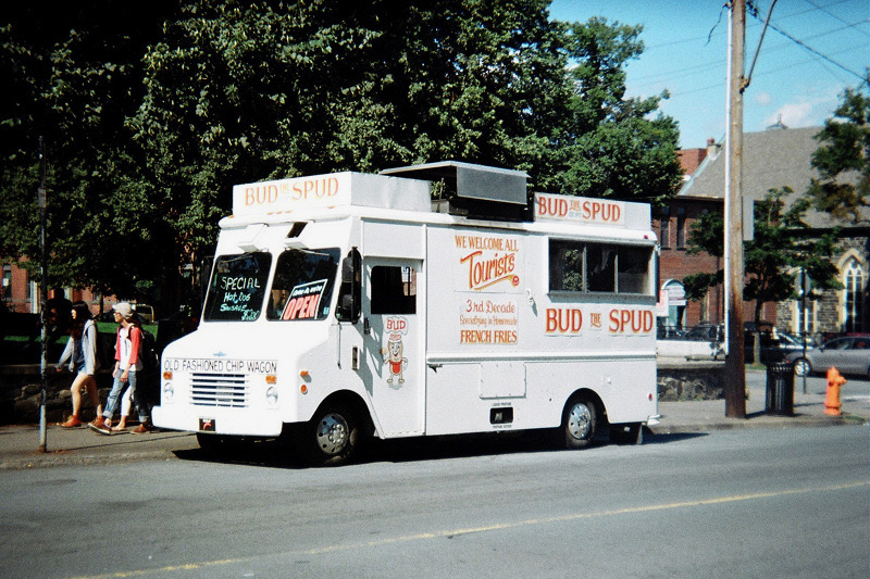 A summer crowd of bystanders gathered around the original Bud the Spud chip wagon on Spring Garden Road
